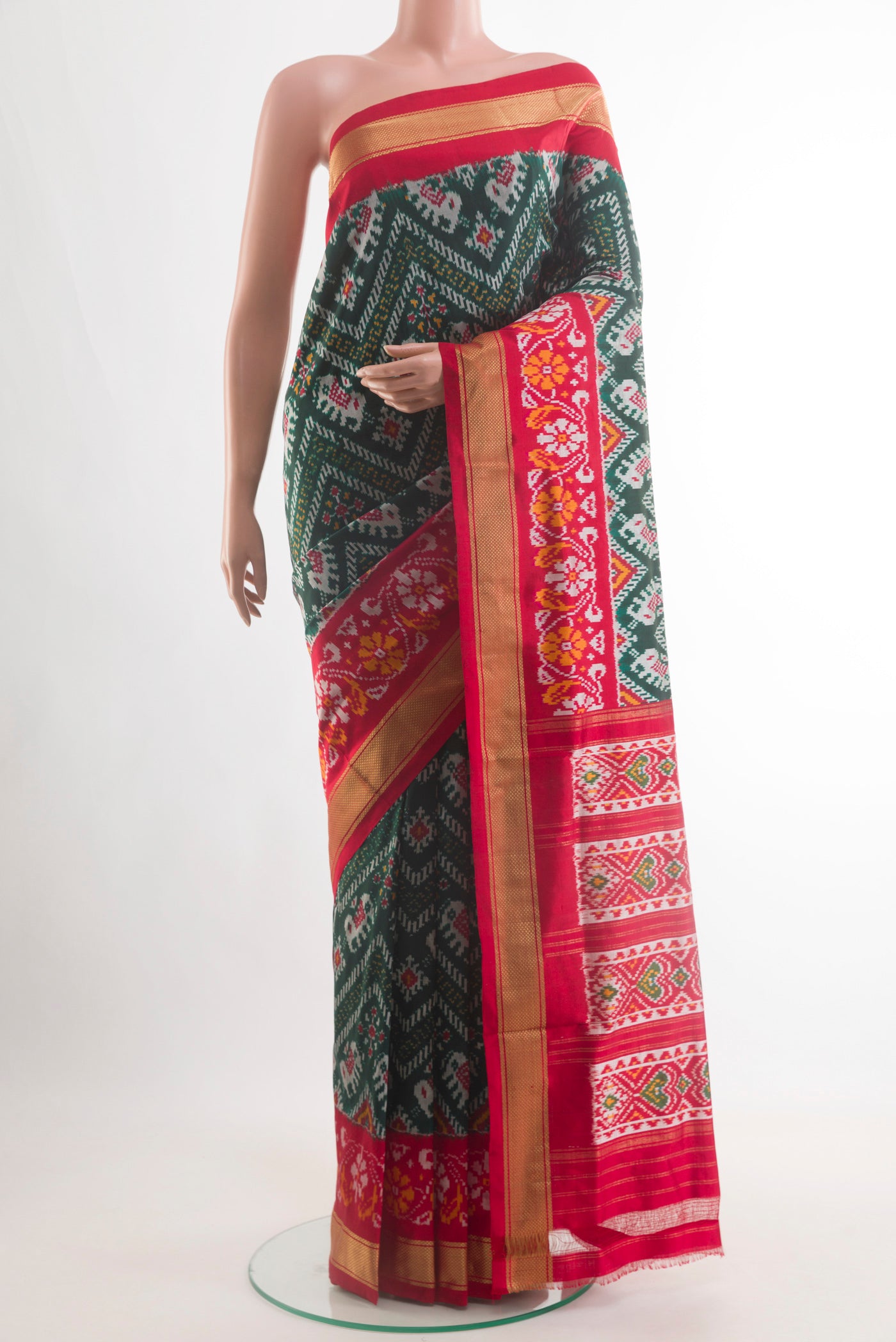 Bottle Green Pochampally Silk Saree with Pure Ikat on the body and Zari Border.  displayed on a mannequin