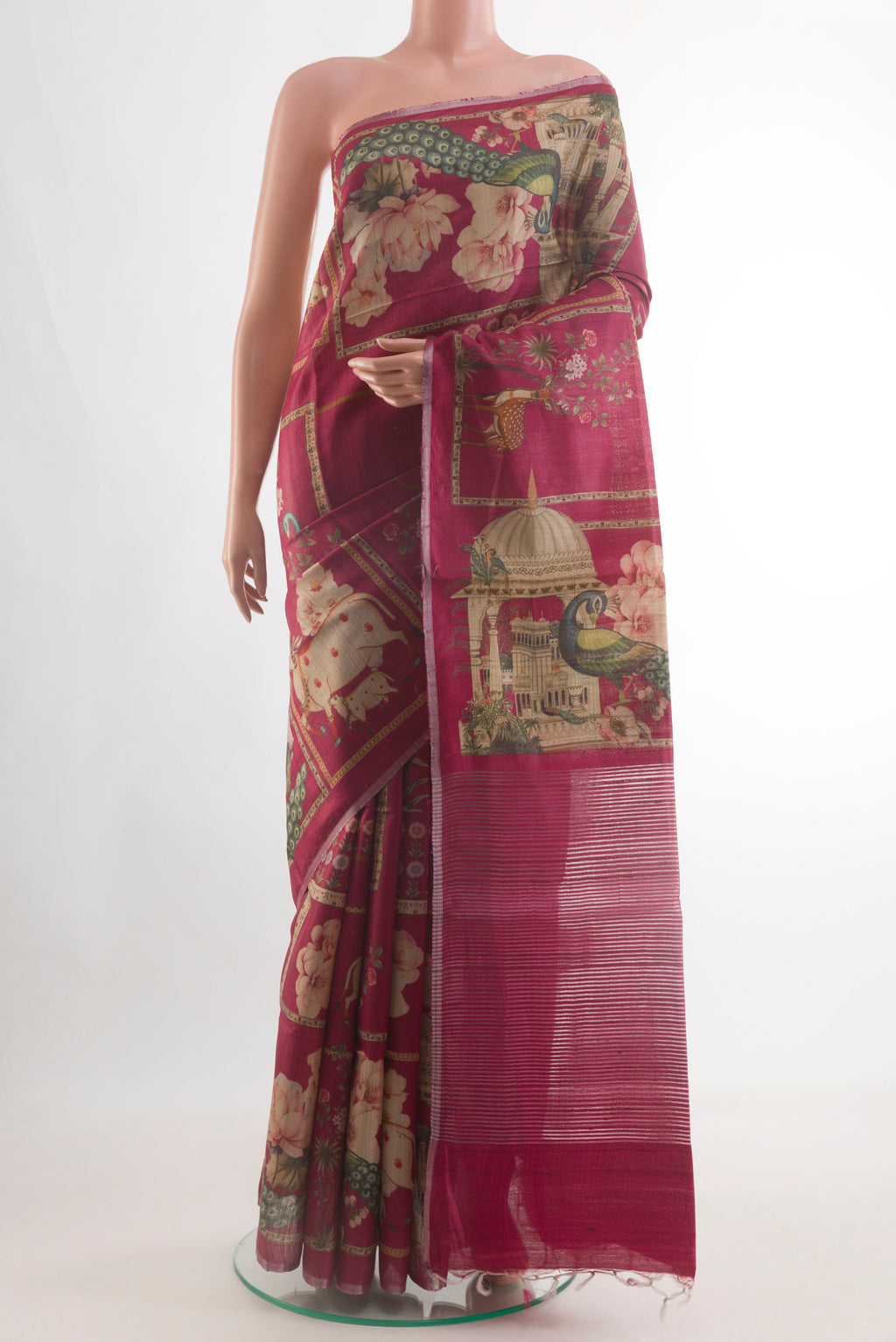 Magenta Tussar Silk Saree with Printed design on the body and Zari Border.  displayed on a mannequin