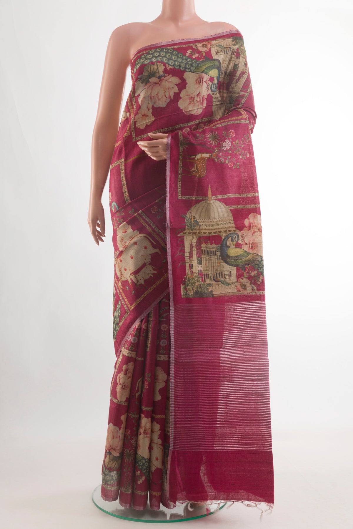 Magenta Tussar Silk Saree with Printed design on the body and Zari Border.  displayed on a mannequin