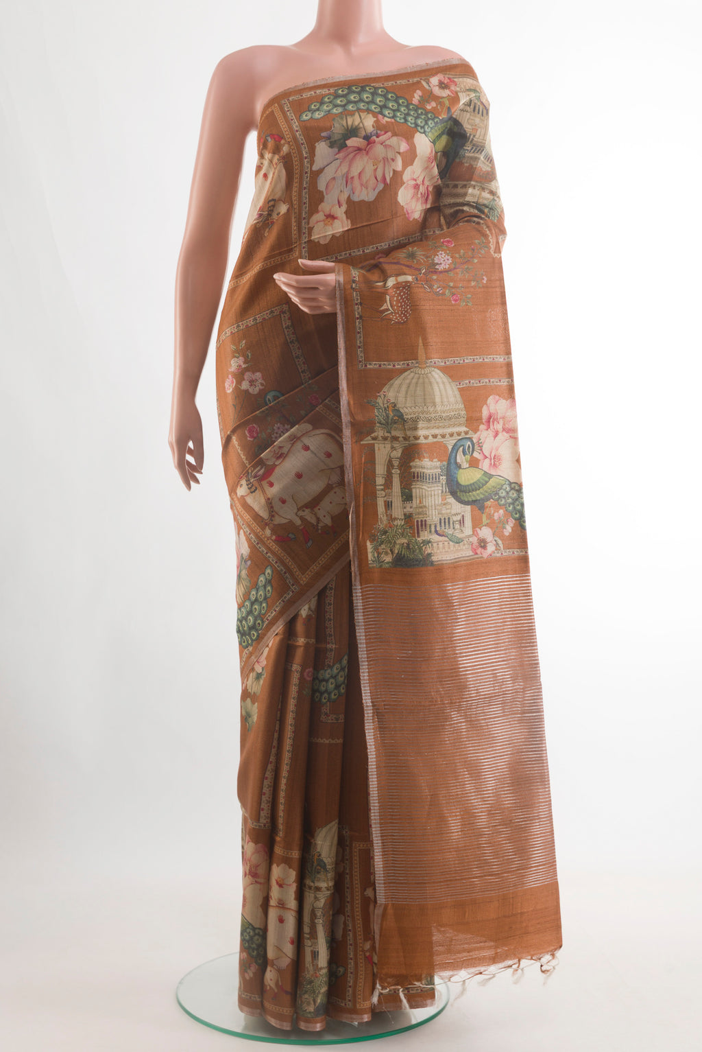 Brown Tussar Silk Saree with Printed design on the body and Zari Border.  displayed on a mannequin