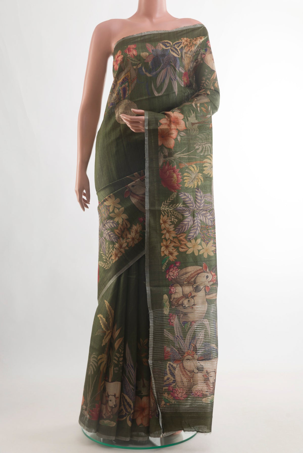Green Tussar Silk Saree with Printed design on the body and Zari Border.  displayed on a mannequin