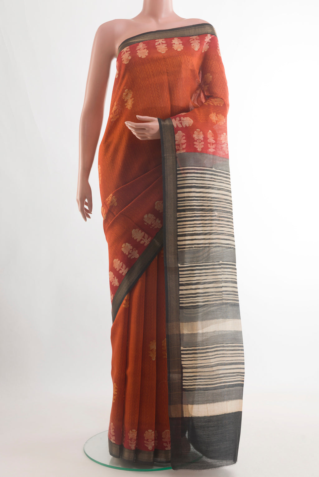 Rust Tussar Silk Saree with Bandhani Print on the body and Zari Border.  displayed on a mannequin