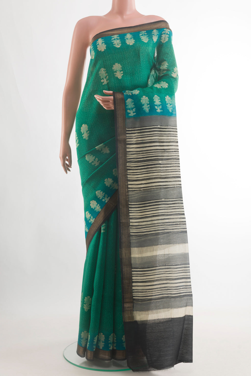 Teal Tussar Silk Saree with Batik Print on the body and Zari Border.  displayed on a mannequin