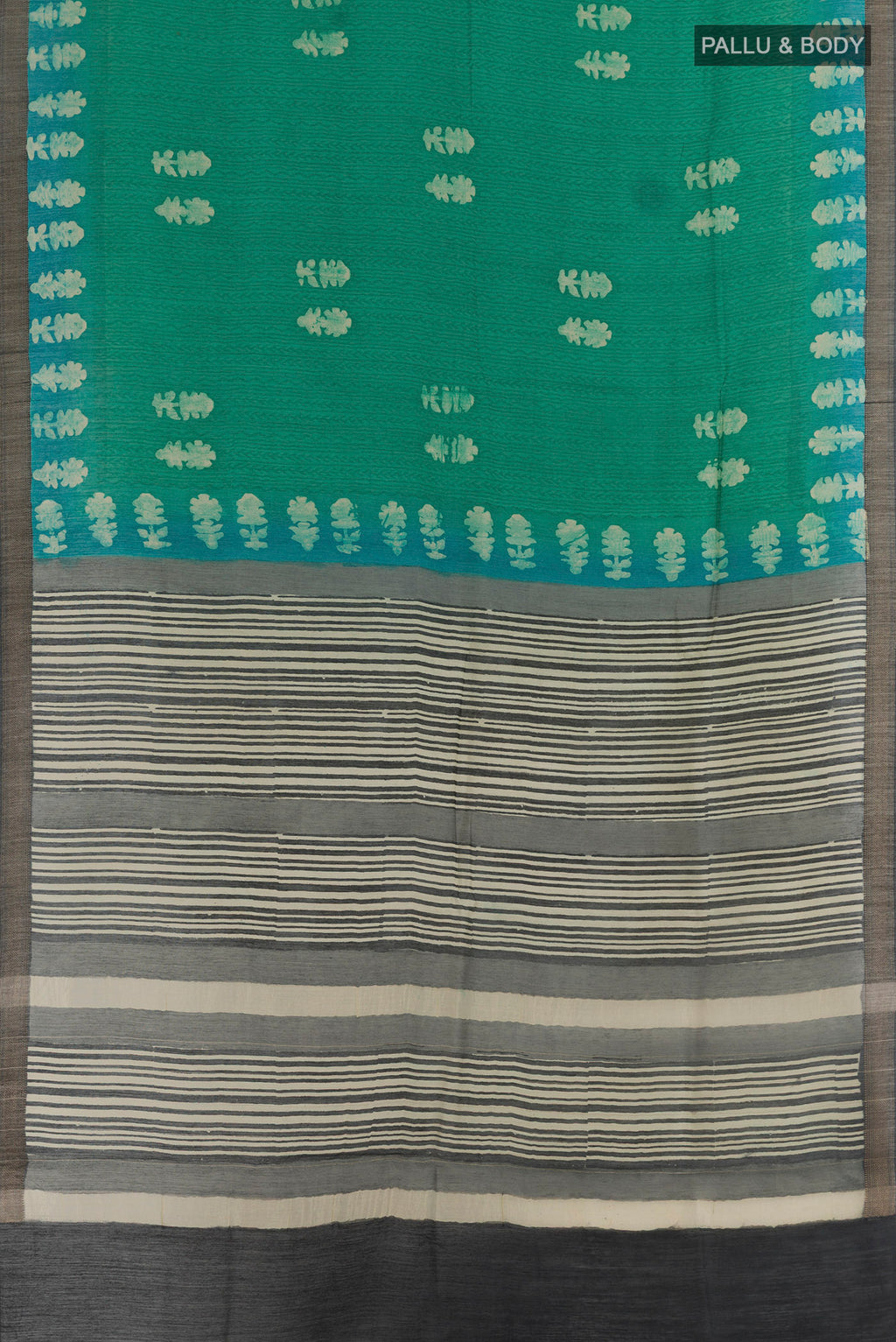 Flat view of Teal Tussar Silk Saree with Batik Print on the body and Zari Border. 