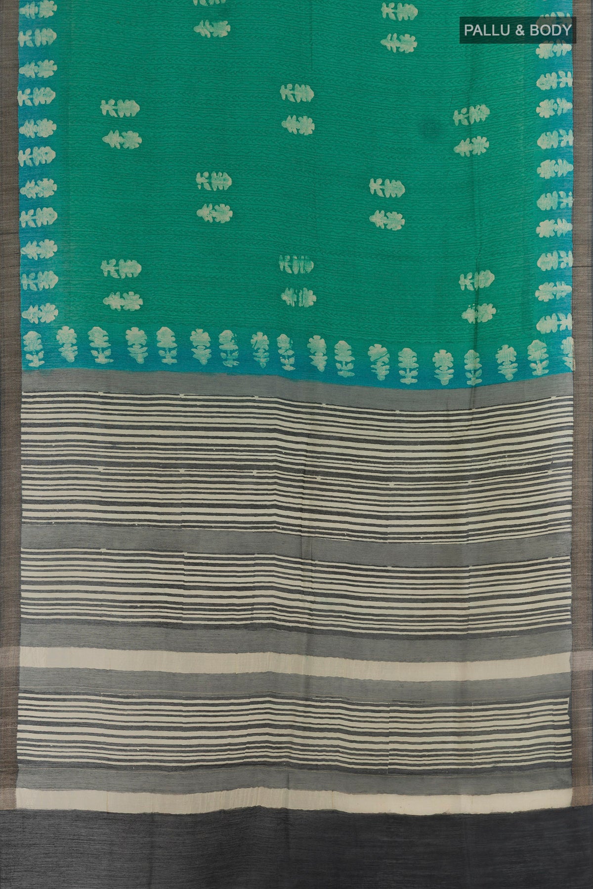 Flat view of Teal Tussar Silk Saree with Batik Print on the body and Zari Border. 