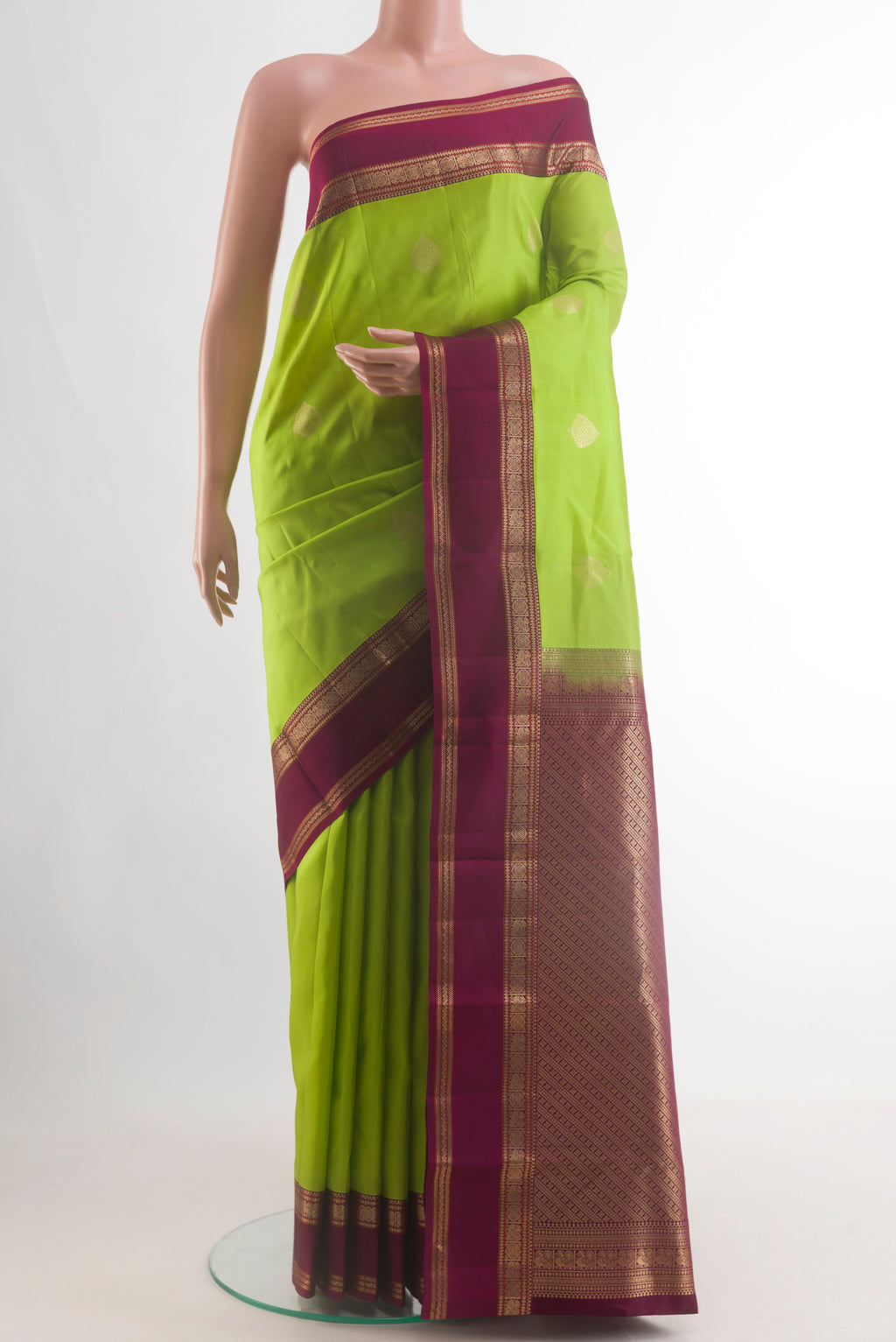 Pure Silk Parrot Green Kanjivaram Saree with Zari Butta on the body and Zari Border.  displayed on a mannequin