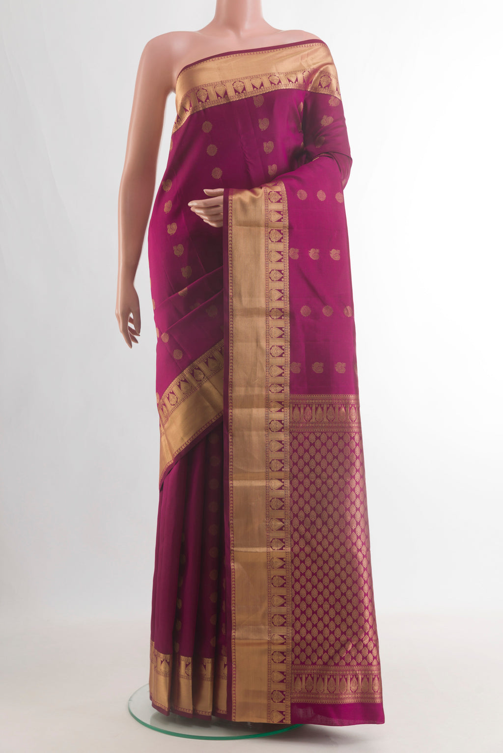 Pure Silk Magenta Kanjivaram Saree with Zari Butta on the body and Zari Border.  displayed on a mannequin