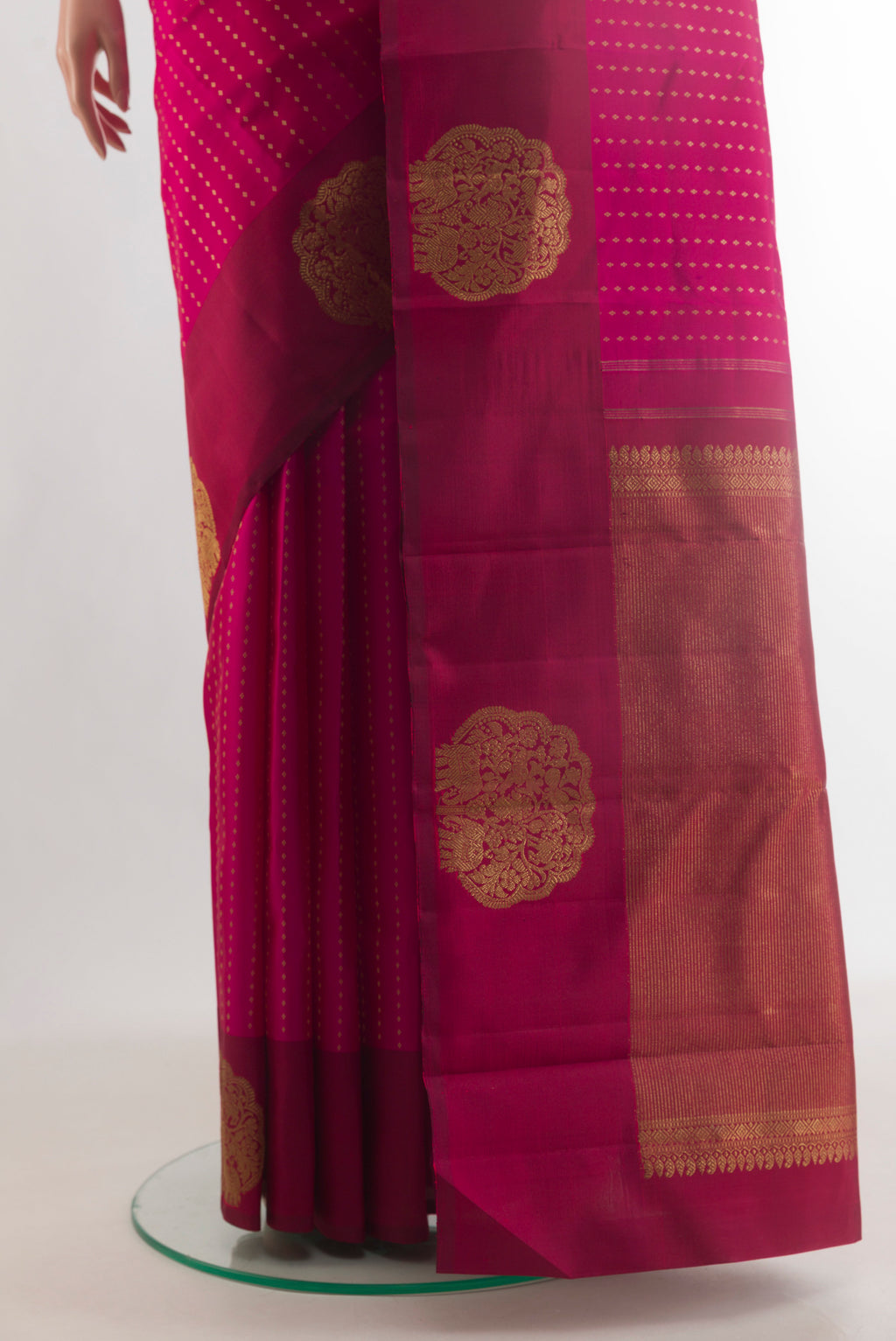 Pleats and pallu of Pure Silk Rani Pink Kanchipuram Saree with Zari Butta on the body and Fancy Border. 
