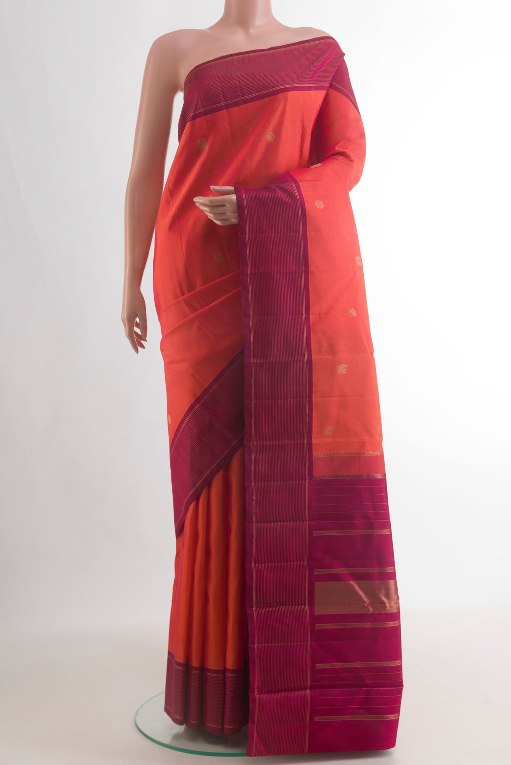 Pure Silk Orange Kanchipuram Saree with Zari Butta on the body and Plain Border.  displayed on a mannequin