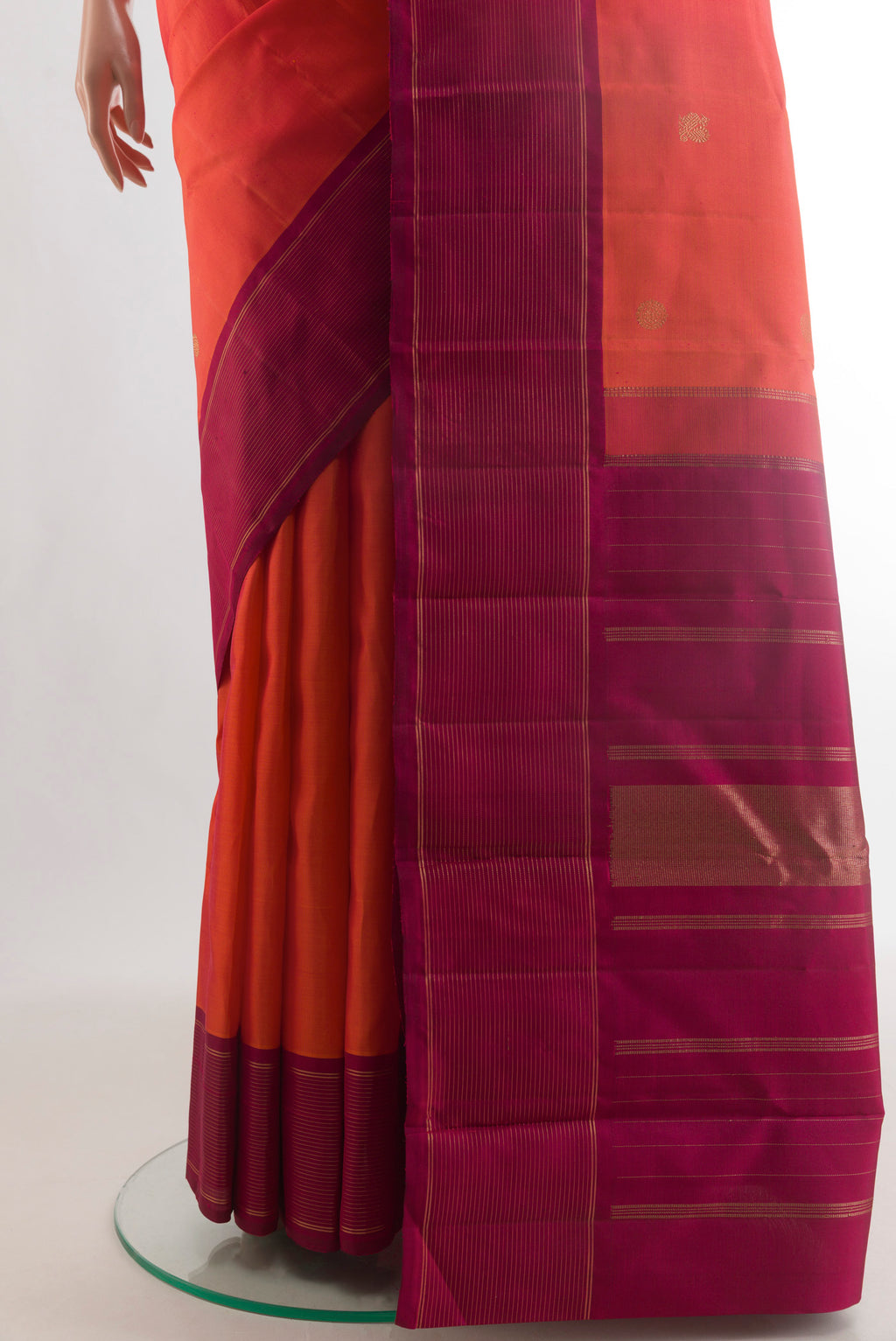 Pleats and pallu of Pure Silk Orange Kanchipuram Saree with Zari Butta on the body and Plain Border. 