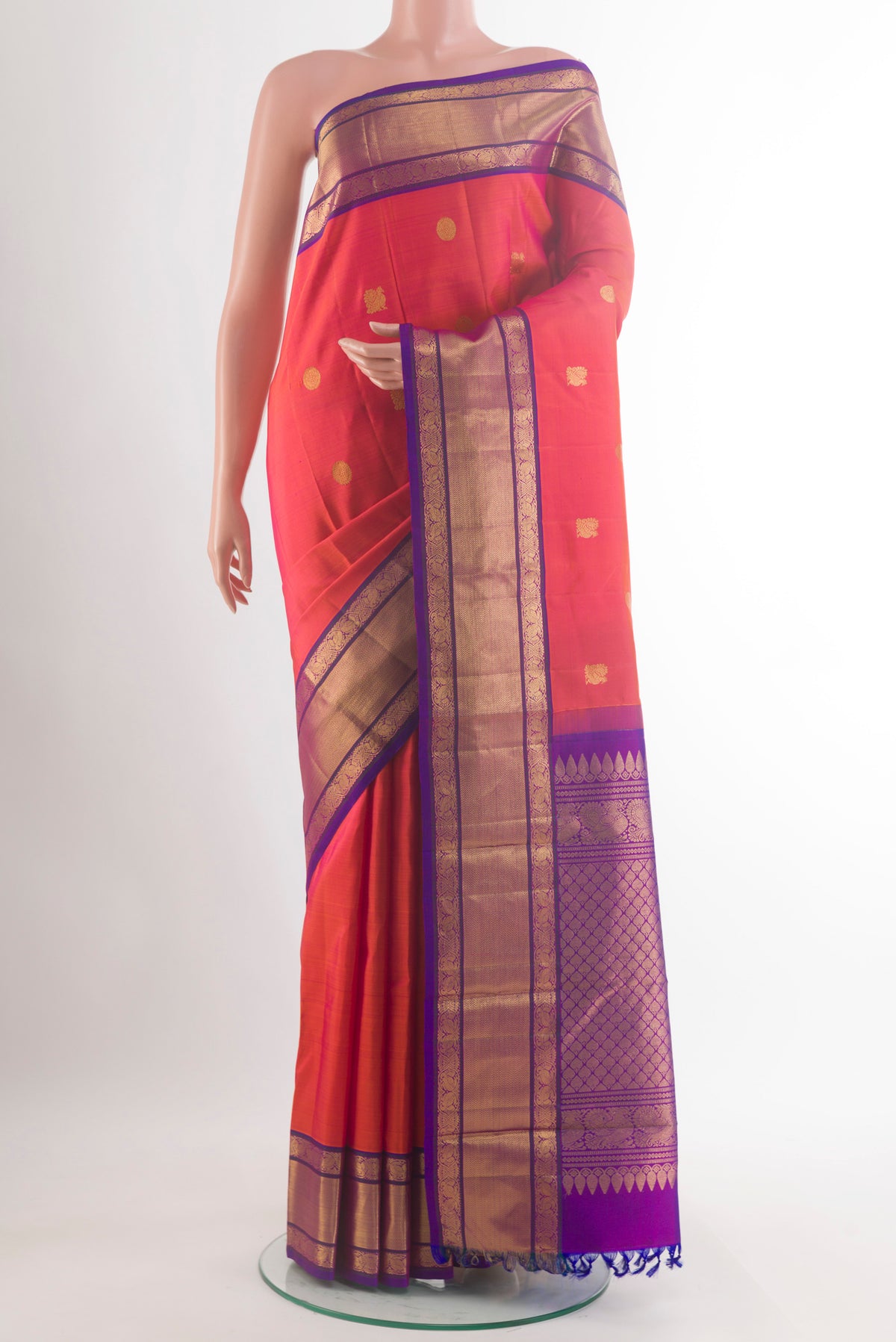 Pure Silk Brick Orange Kanjivaram Saree with Zari Butta on the body and Zari Border.  displayed on a mannequin
