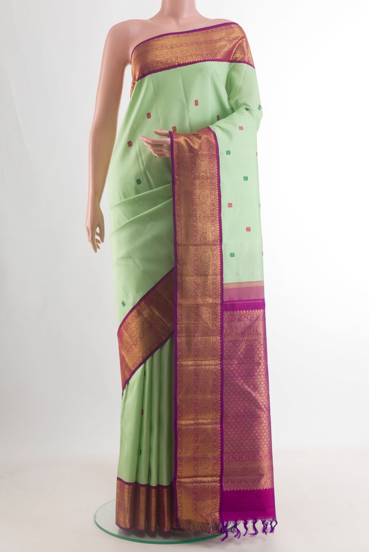 Pure Silk Light Green Kanchipuram Saree with Thread Butta on the body and Zari Border.  displayed on a mannequin