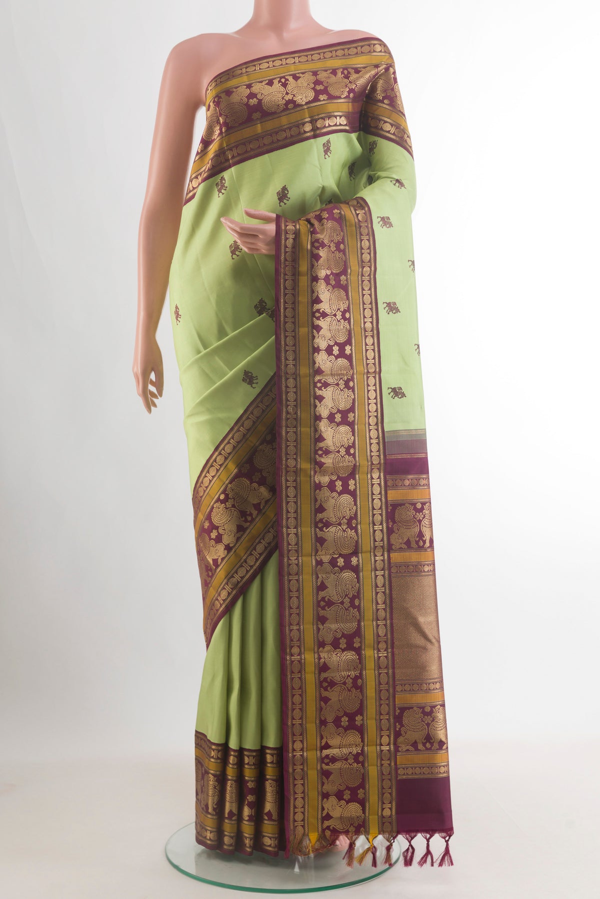 Pure Silk Pista Green Kanjivaram Saree with Thread Butta on the body and Zari Border.  displayed on a mannequin