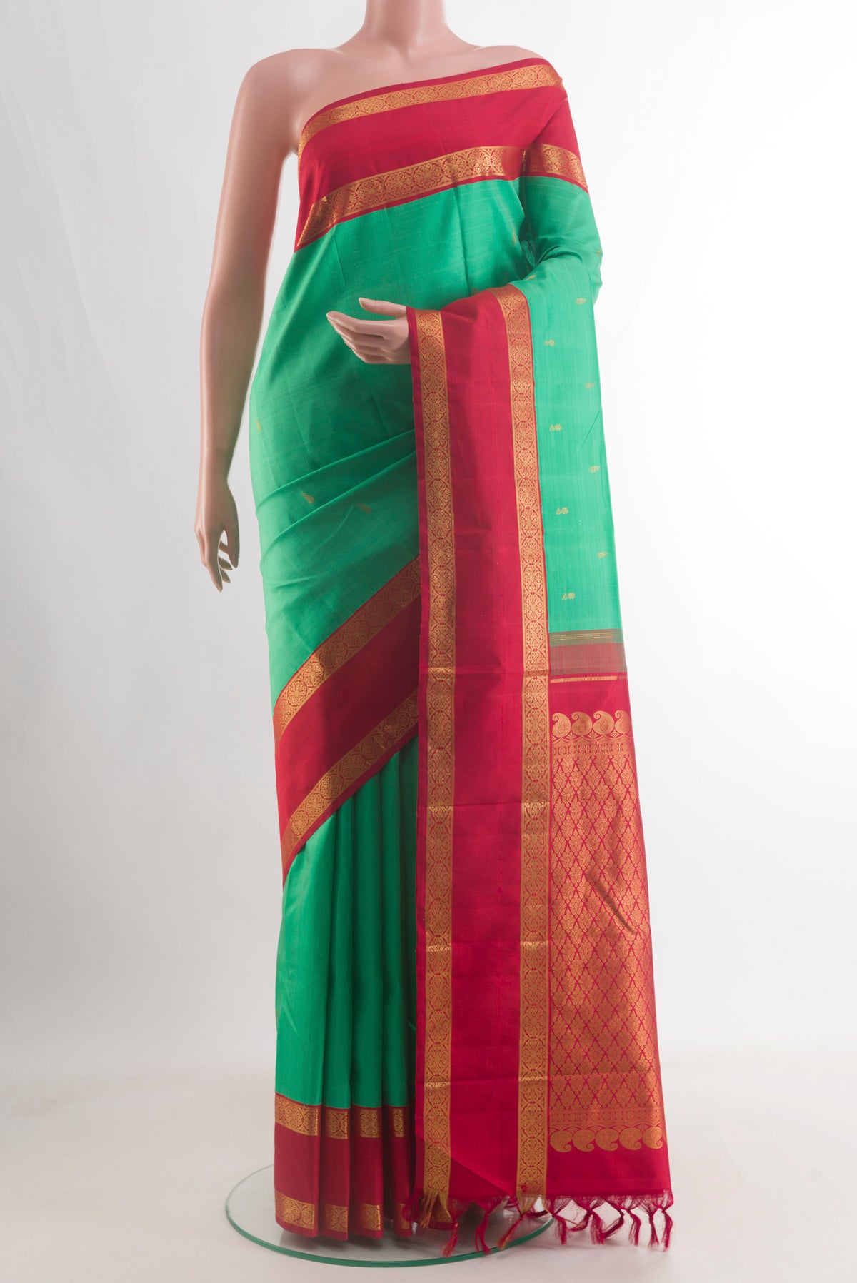 Pure Silk Green Kanjivaram Saree with Zari Butta on the body and Zari Border.  displayed on a mannequin