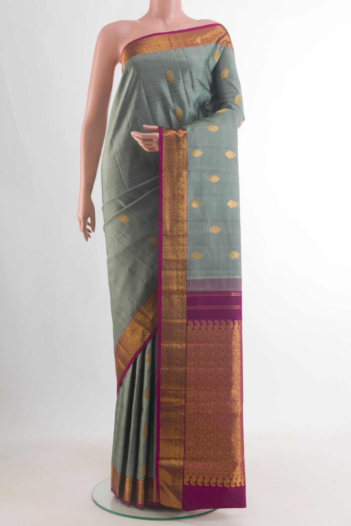 Pure Silk Sage Green Kanchipuram Saree with Zari Butta on the body and Zari Border.  displayed on a mannequin