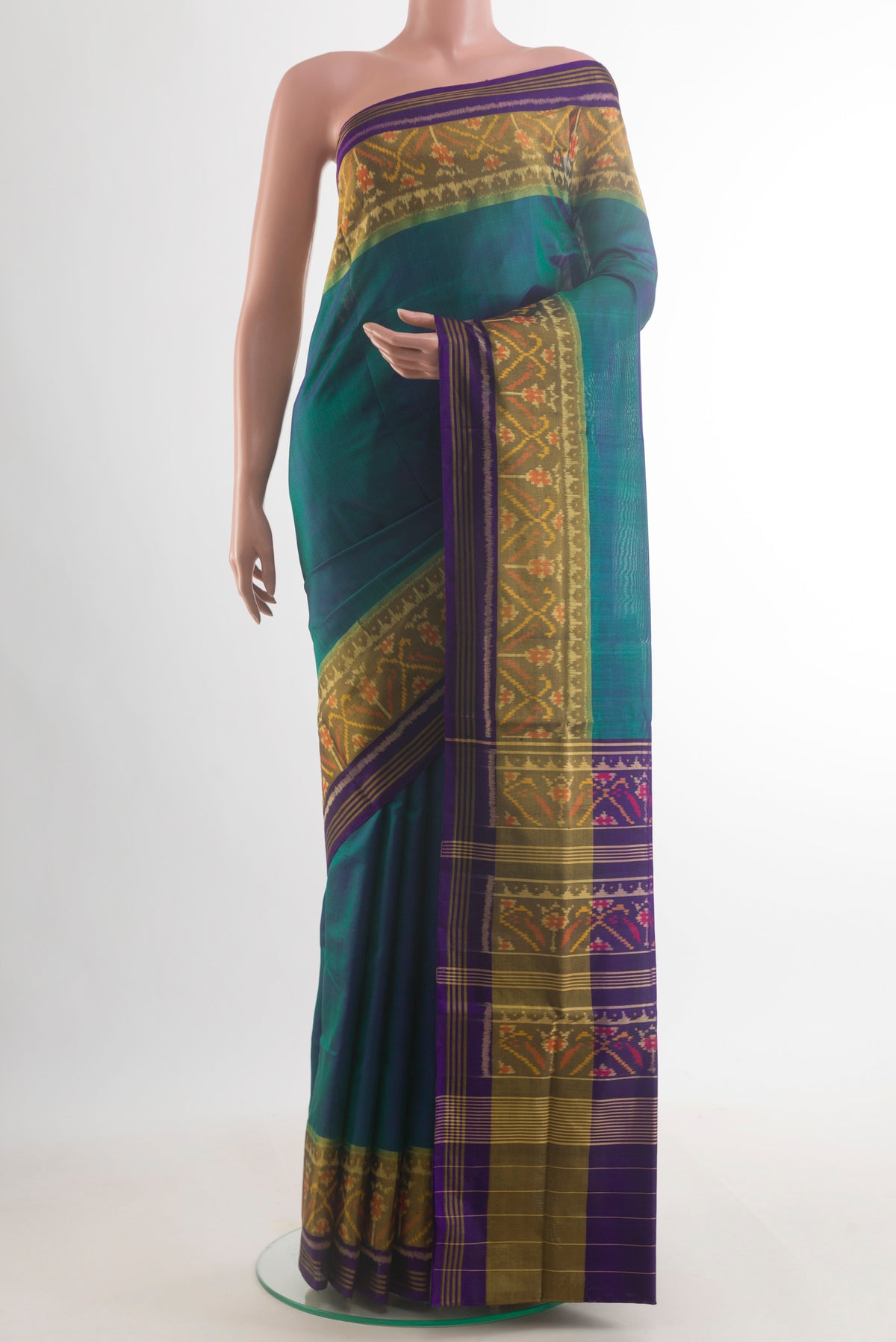 Pure Silk Peacock Blue Rajkot Patola Saree with Plain Body and Ikat Border.  displayed on a mannequin