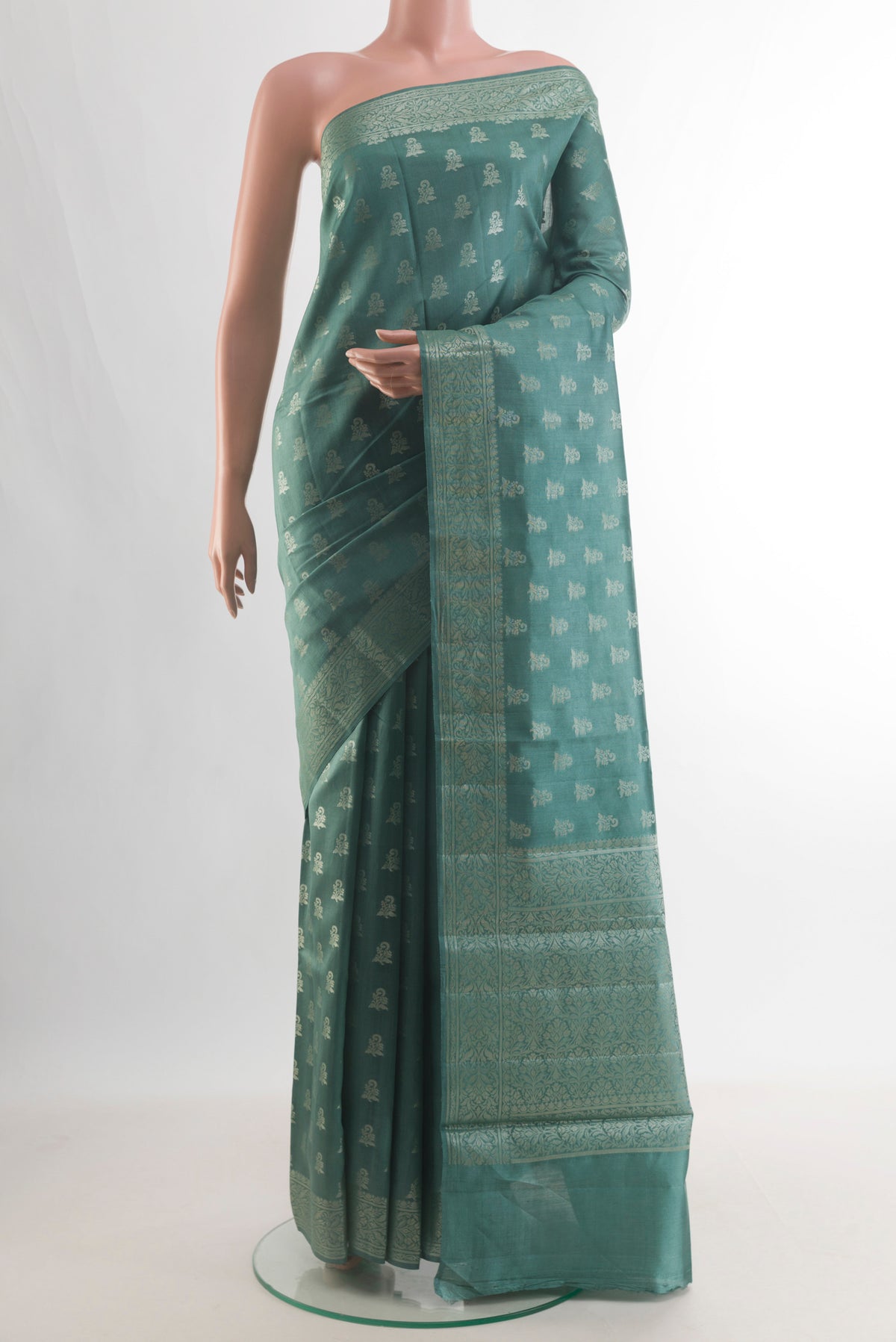 Pure Silk Green Banarasi Raw Saree with Zari Butta on the body and Zari Border.  displayed on a mannequin