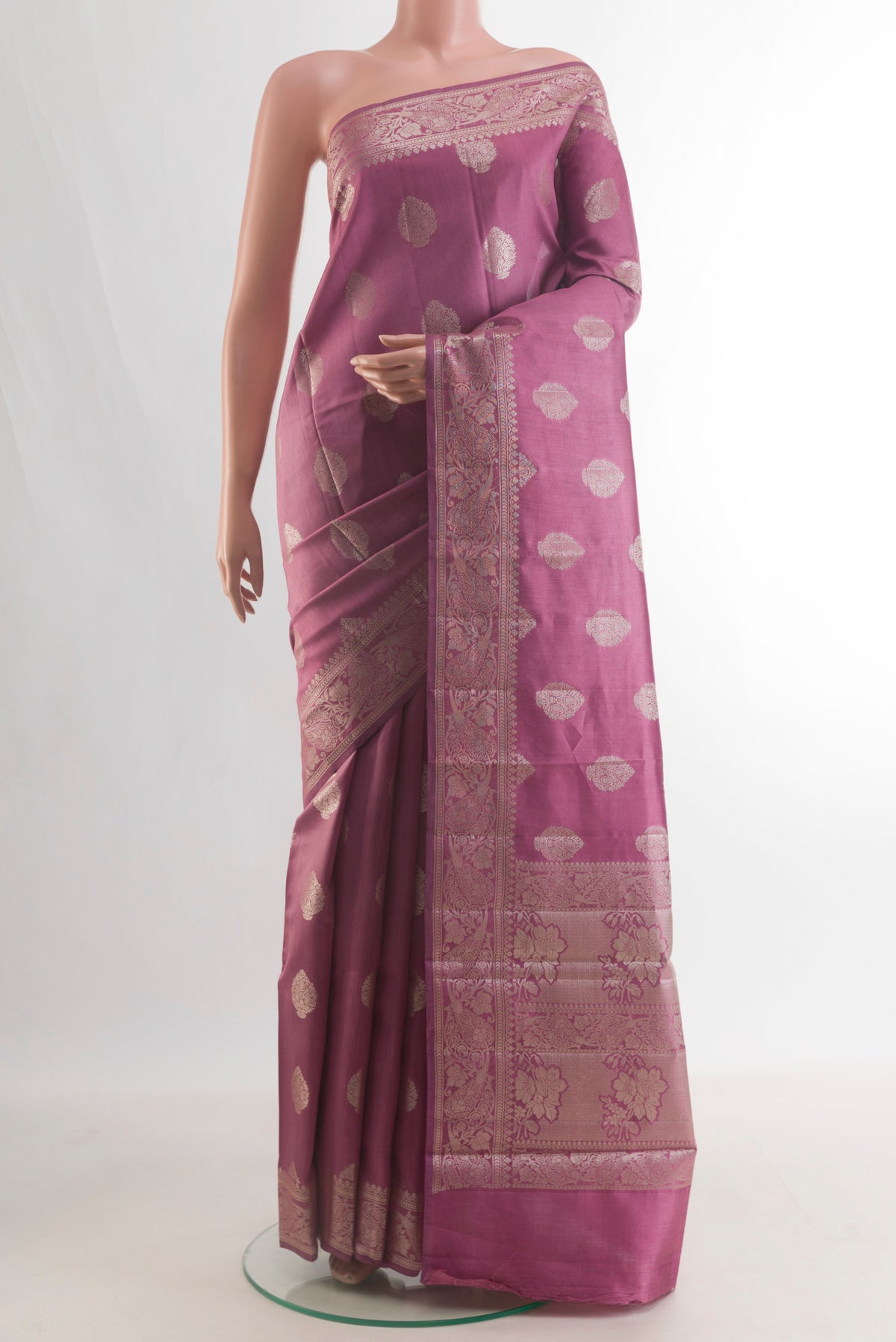 Pure Silk Mauve Banarasi Raw Saree with Zari Butta on the body and Zari Border.  displayed on a mannequin