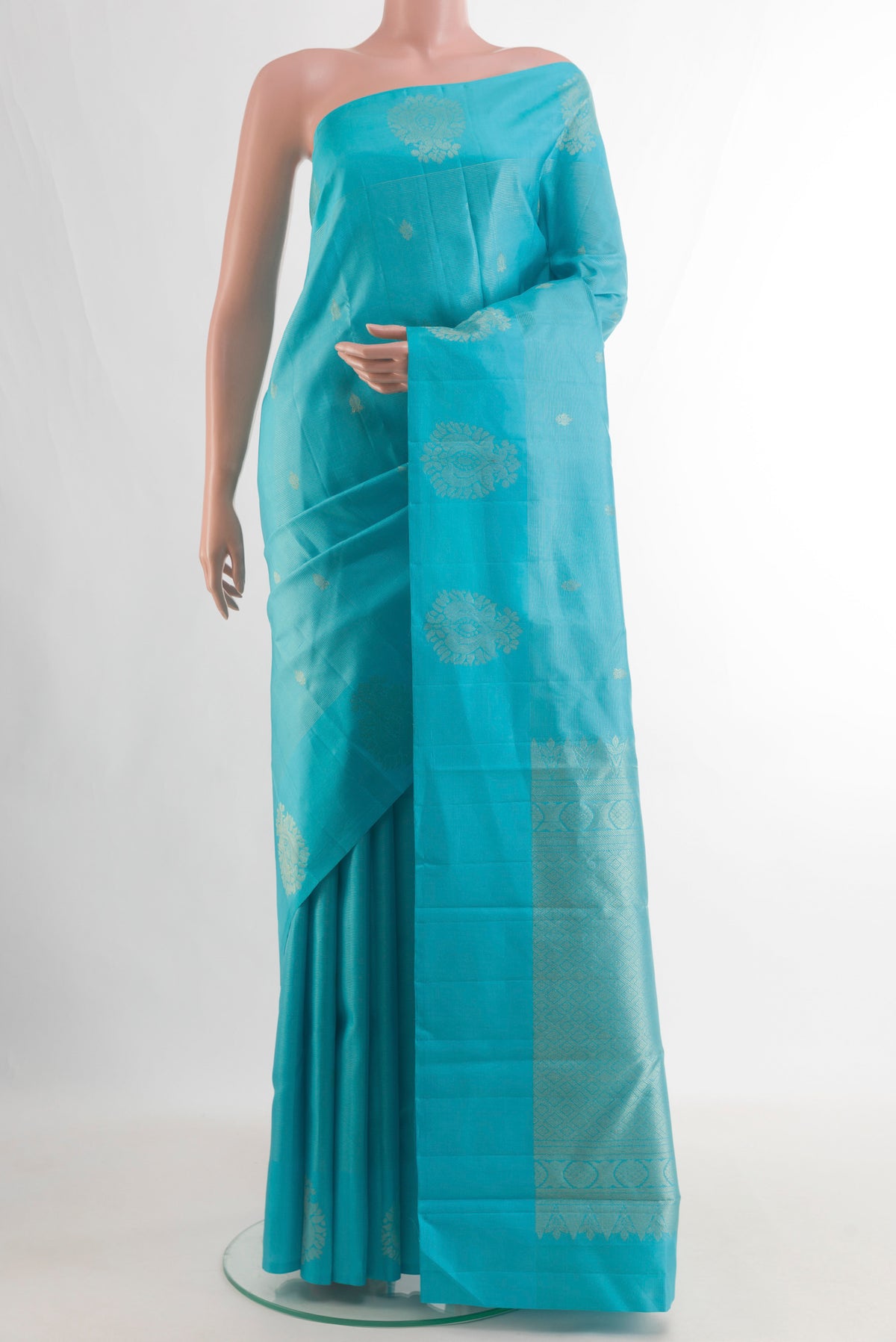 Pure Silk Blue Kanchipuram Saree with Zari Butta on the body and Zari Border.  displayed on a mannequin
