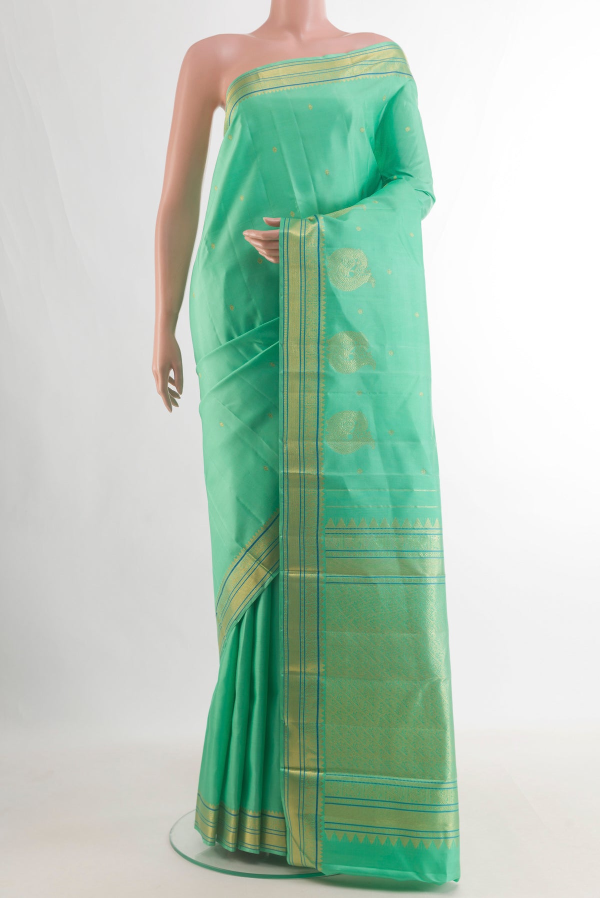 Pure Silk Green Kanjivaram Saree with Zari Butta on the body and Zari Border.  displayed on a mannequin