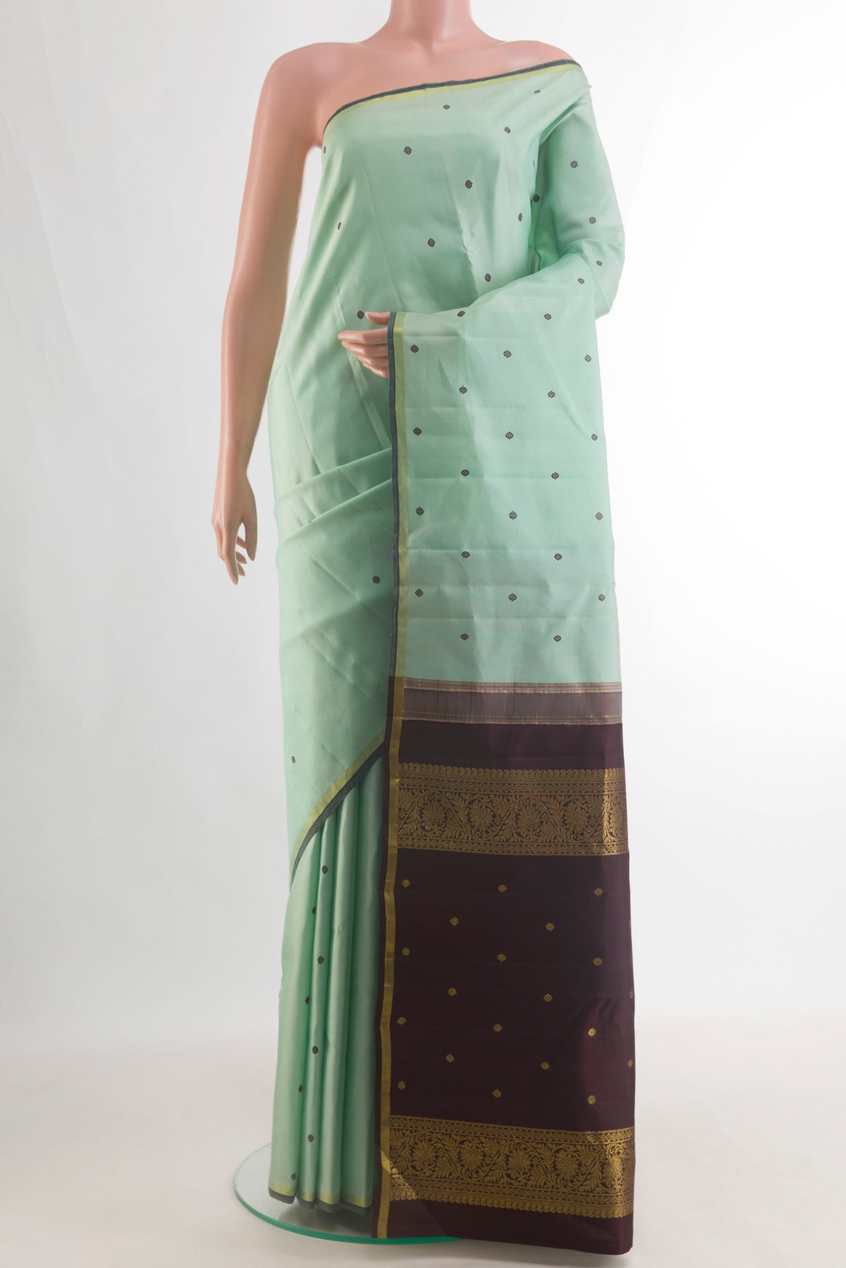 Pure Silk Mint Green Kanchipuram Saree with Thread Butta on the body and Zari Border.  displayed on a mannequin