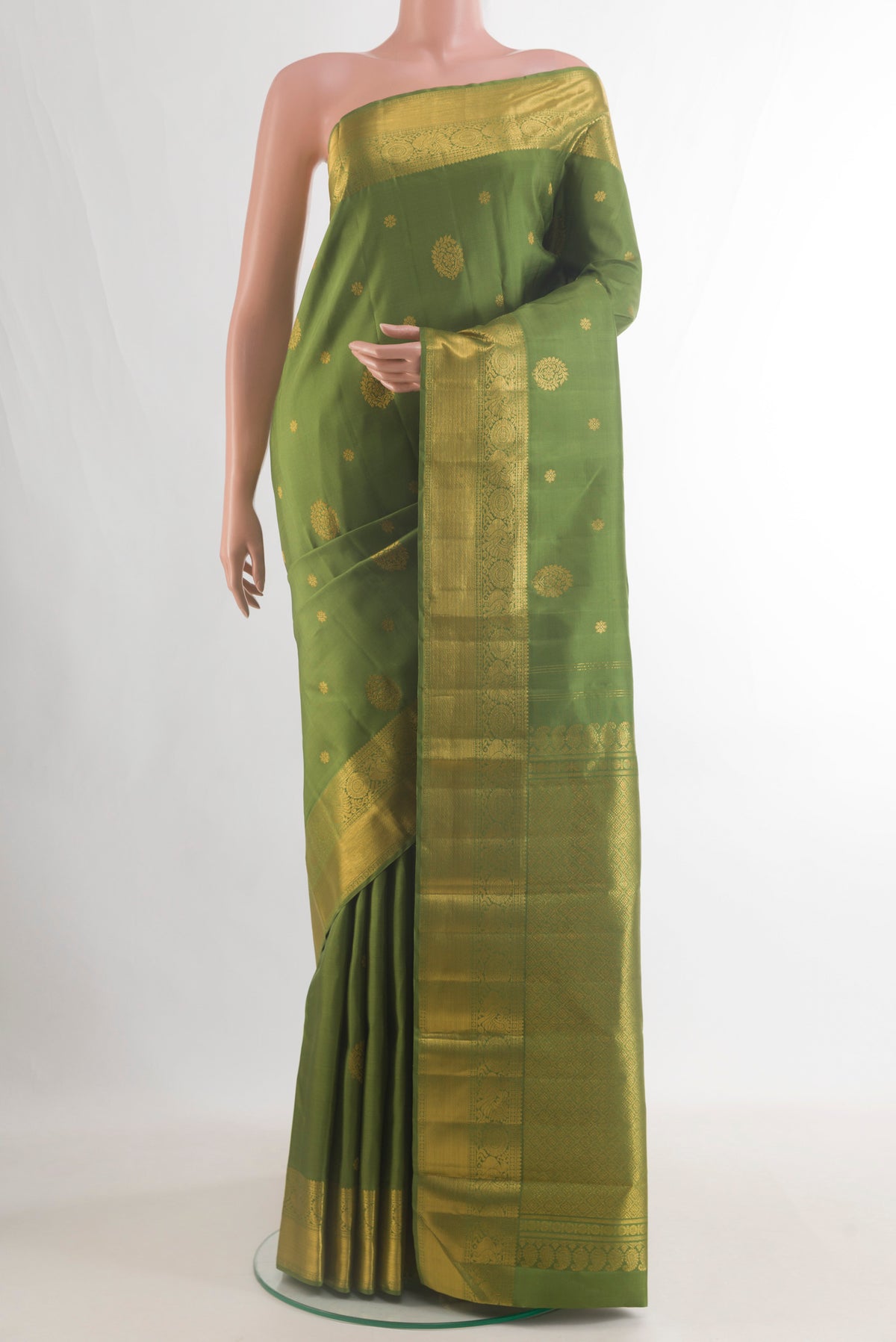 Pure Silk Mehandi Green Kanjivaram Saree with Zari Butta on the body and Zari Border.  displayed on a mannequin