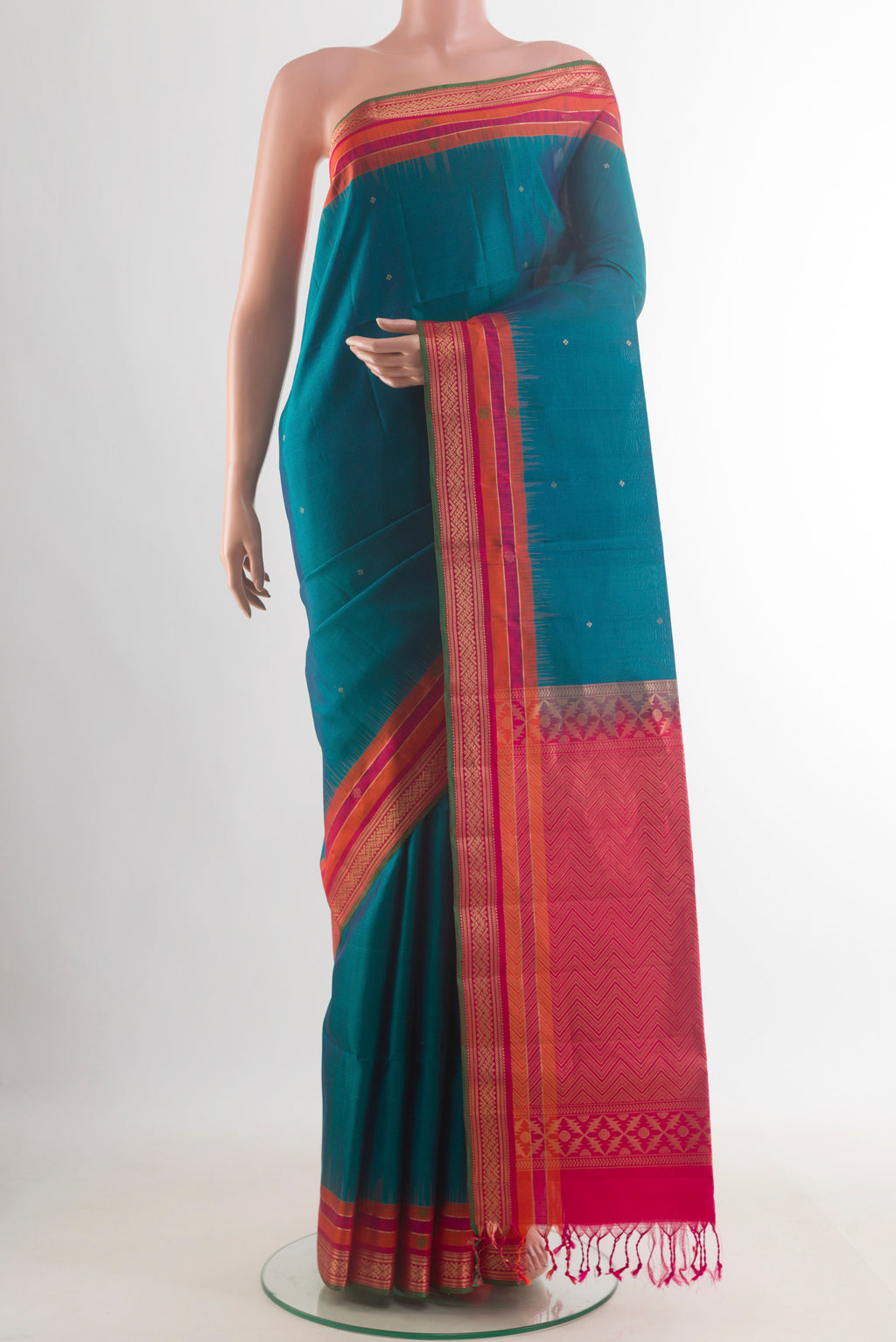 Pure Silk Peacock Blue Soft Saree with Zari Butta on the body and Zari Border.  displayed on a mannequin