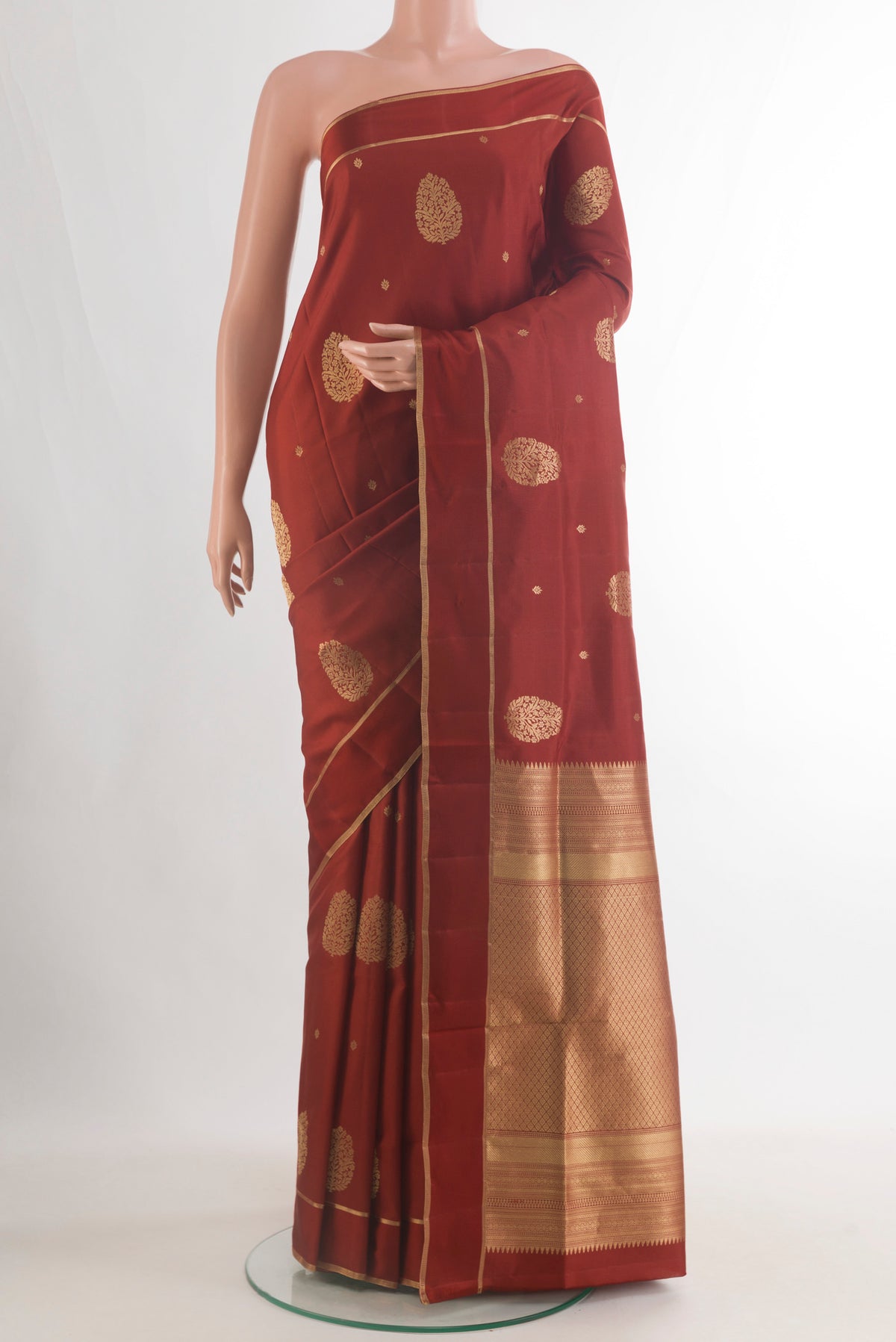 Pure Silk Rust Soft Saree with Zari Butta on the body and Zari Border.  displayed on a mannequin