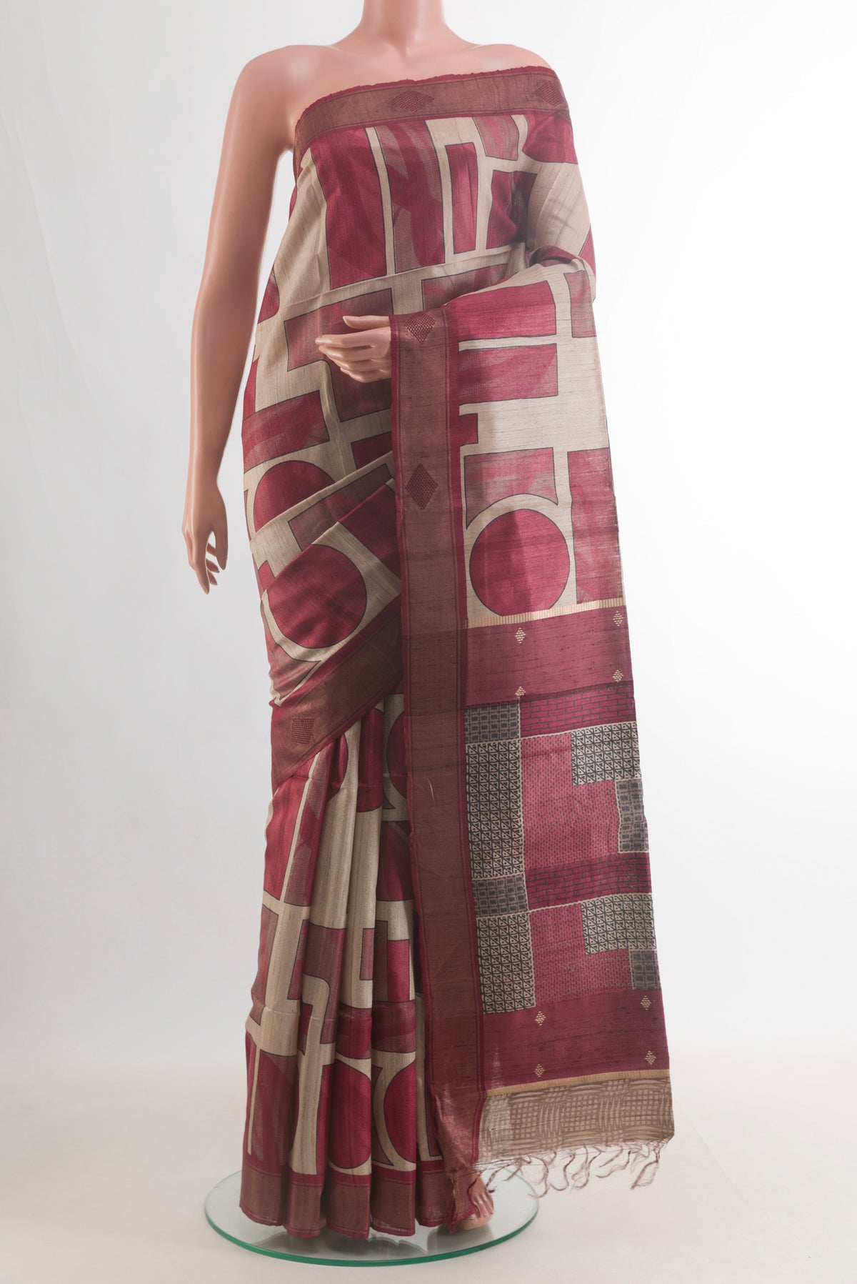 Maroon Tussar Saree with Printed design on the body and Zari Border.  displayed on a mannequin