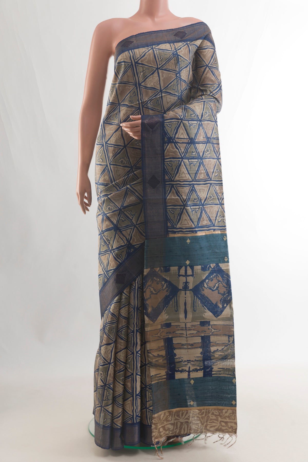 Beige Tussar Saree with Printed design on the body and Zari Border.  displayed on a mannequin