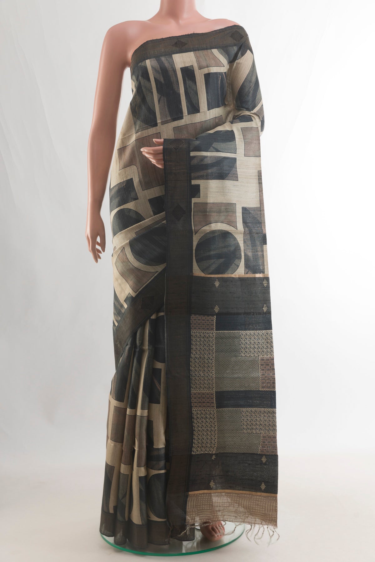 Beige Tussar Saree with Printed design on the body and Zari Border.  displayed on a mannequin
