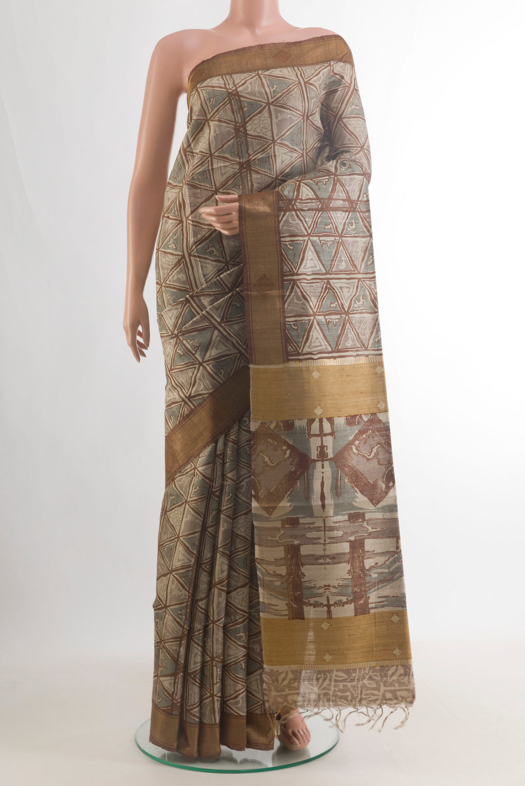 Beige Tussar Saree with Printed design on the body and Zari Border.  displayed on a mannequin
