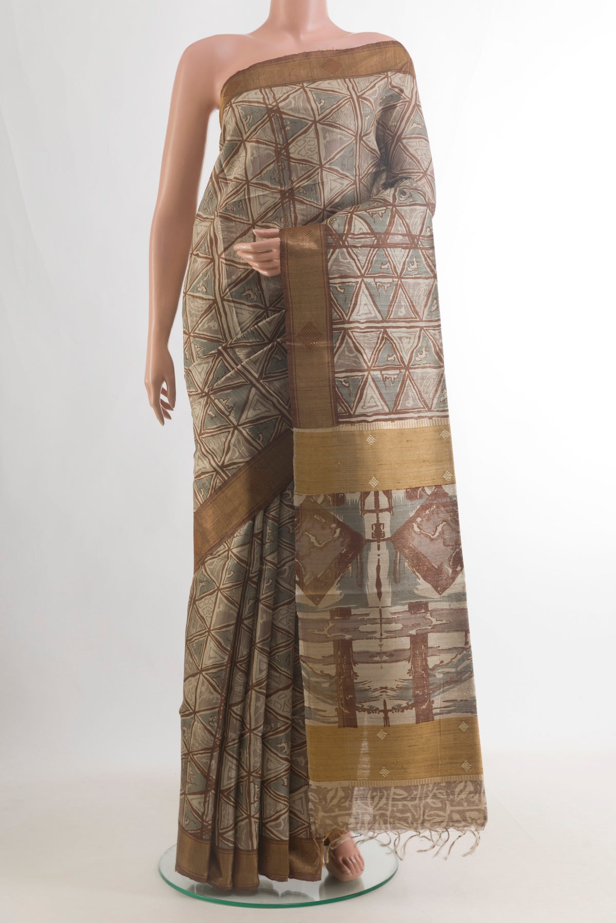 Beige Tussar Saree with Printed design on the body and Zari Border.  displayed on a mannequin
