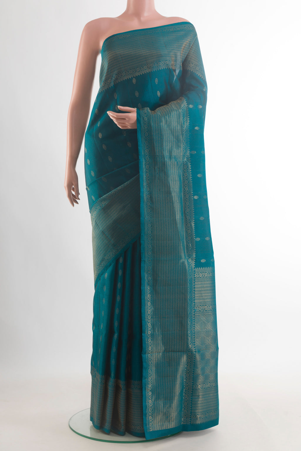 Pure Silk Peacock Blue Soft Saree with Zari Butta on the body and Zari Border.  displayed on a mannequin