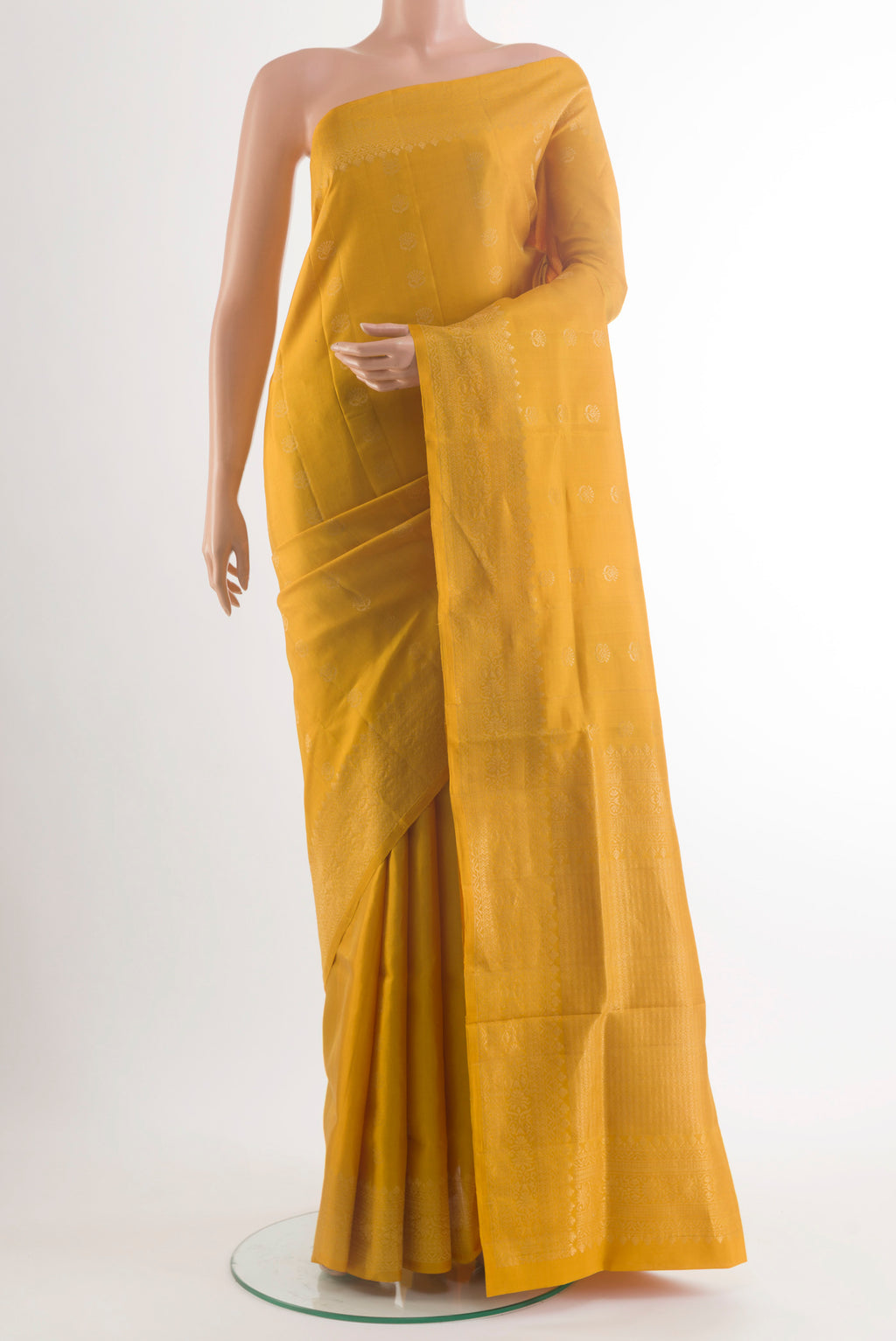 Pure Silk Mustard Soft Saree with Zari Butta on the body and Zari Border.  displayed on a mannequin