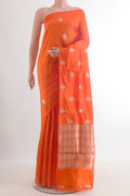 Pure Silk Orange Banarasi Katan Saree with Zari Butta on the body and Without Border.  displayed on a mannequin