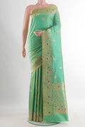 Pure Silk Green Banarasi Saree with Zari Butta on the body and Zari Border.  displayed on a mannequin