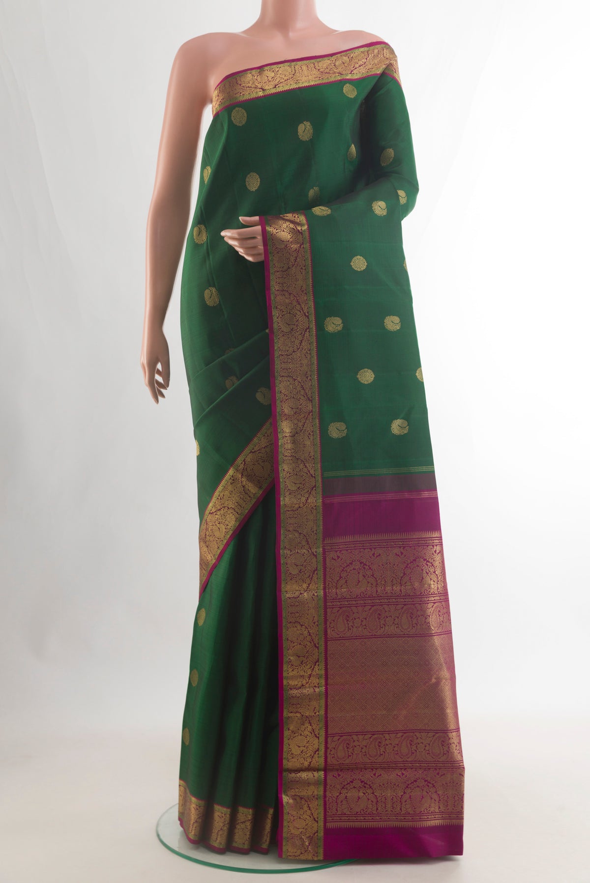 Pure Silk Pure Zari Bottle Green Kanjivaram Saree with Zari Butta on the body and Zari Border.  displayed on a mannequin