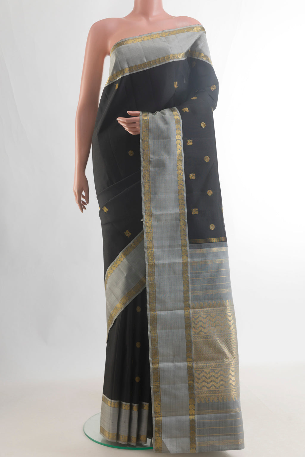 Pure Silk Pure Zari Black Kanchipuram Saree with Zari Butta on the body and Zari Border.  displayed on a mannequin