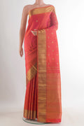 Pure Silk Pure Zari Brick Orange Kanjivaram Saree with Zari Butta on the body and Zari Border.  displayed on a mannequin
