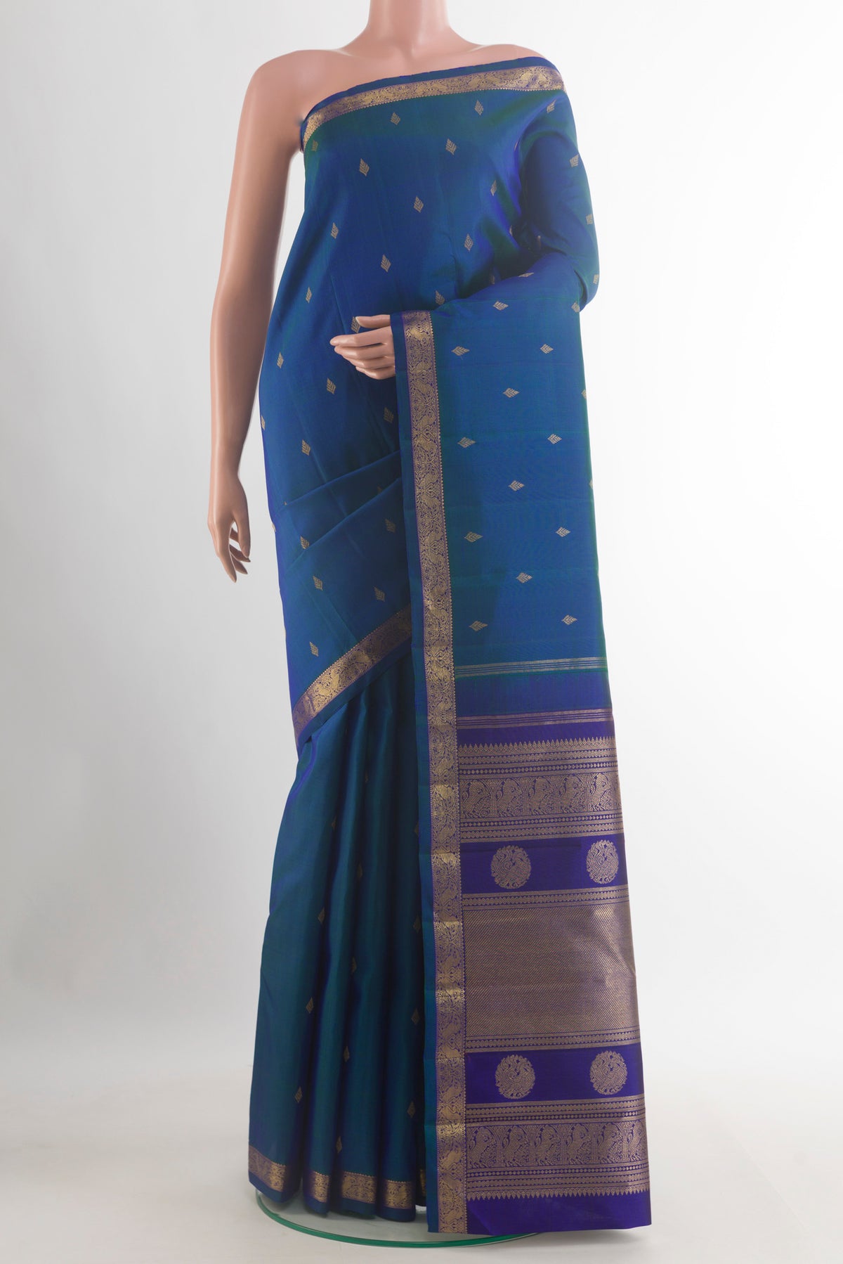 Pure Silk Pure Zari Peacock Blue Kanchipuram Saree with Zari Butta on the body and Zari Border.  displayed on a mannequin