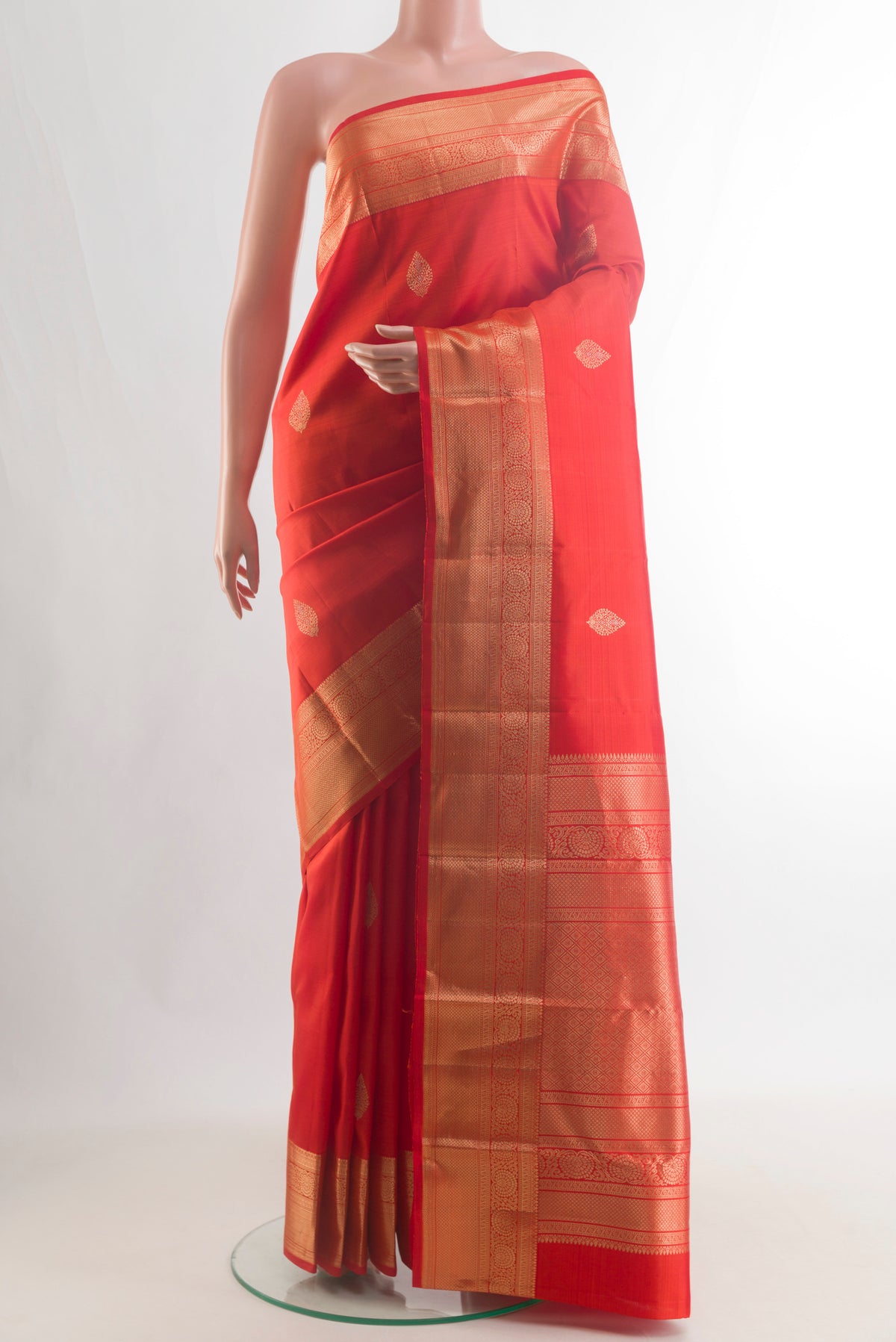 Pure Silk Orange Kanchipuram Saree with Zari Butta on the body and Zari Border.  displayed on a mannequin