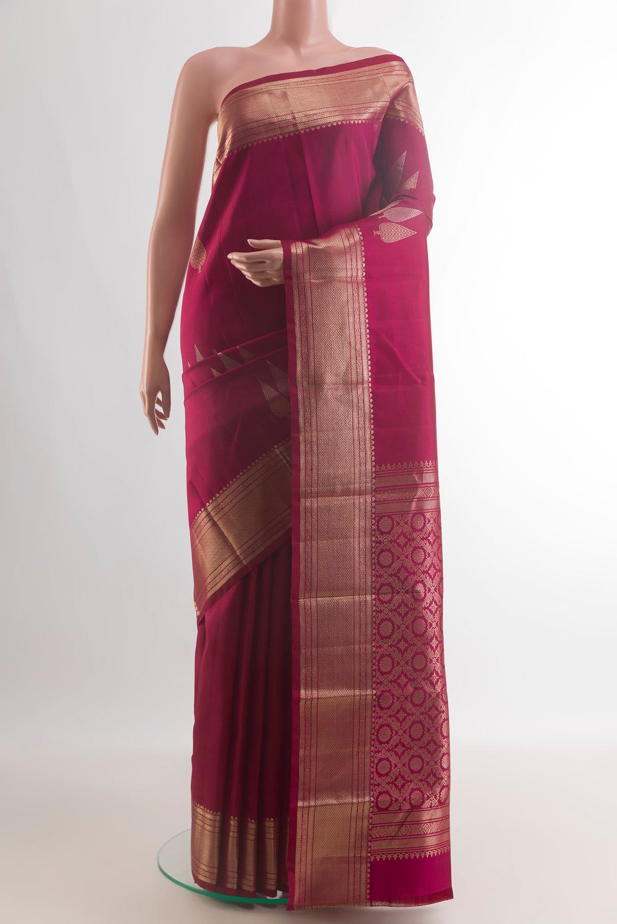 Pure Silk Maroon Kanchipuram Saree with Zari Butta on the body and Zari Border.  displayed on a mannequin