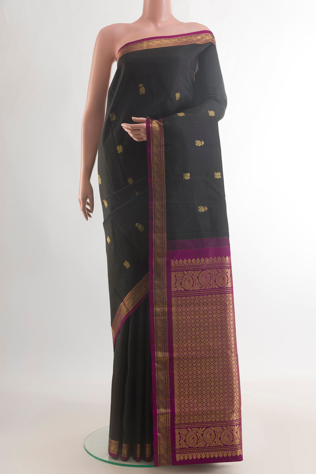 Pure Silk Black Kanchipuram Saree with Zari Butta on the body and Zari Border.  displayed on a mannequin