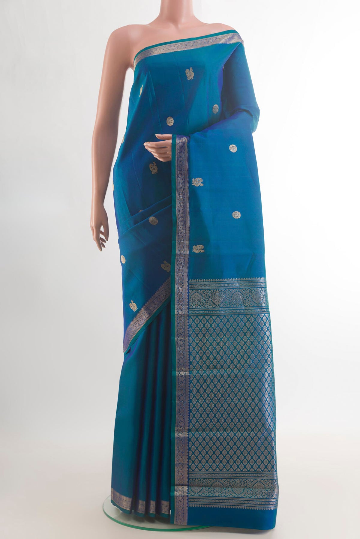 Pure Silk Peacock Blue Kanchipuram Saree with Zari Butta on the body and Zari Border.  displayed on a mannequin