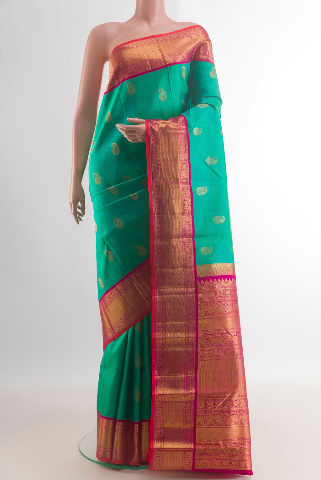Pure Silk Green Kanjivaram Saree with Zari Butta on the body and Zari Border.  displayed on a mannequin