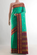 Pure Silk Sea Green Kanjivaram Saree with Zari Butta on the body and Zari Border.  displayed on a mannequin