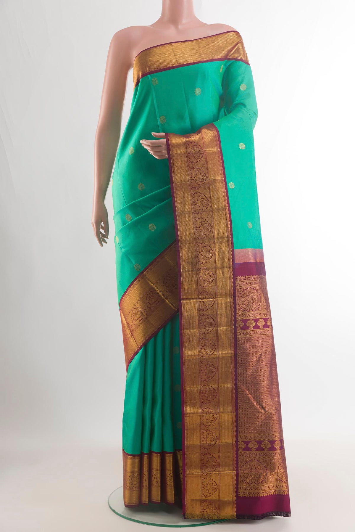 Pure Silk Sea Green Kanjivaram Saree with Zari Butta on the body and Zari Border.  displayed on a mannequin