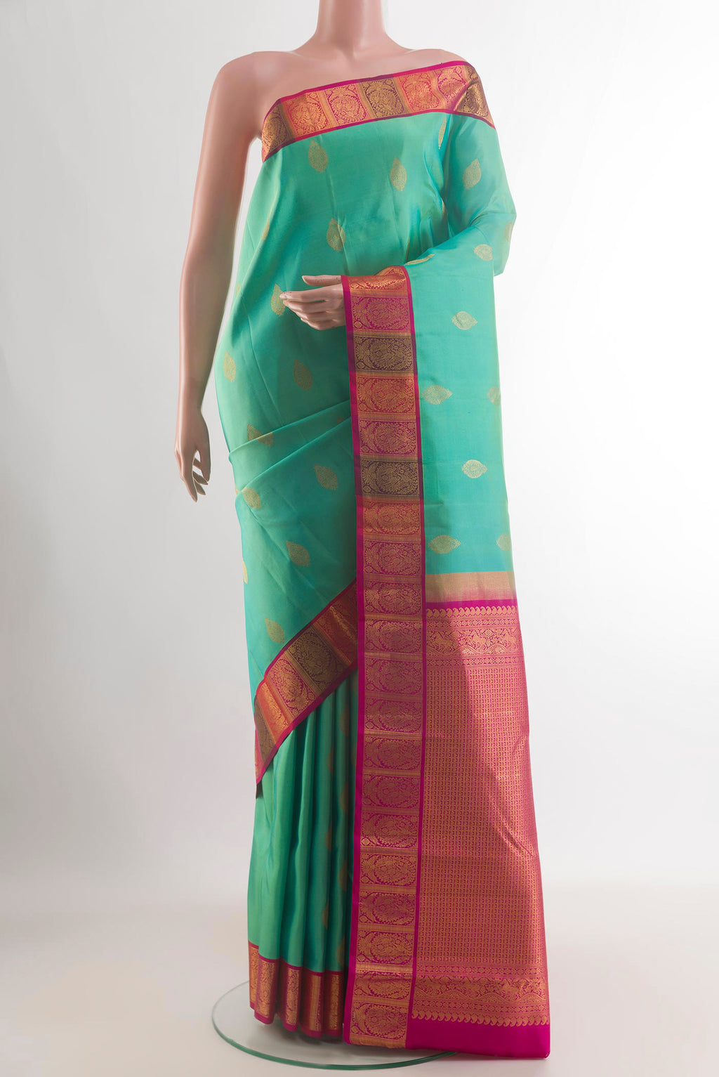 Pure Silk Green Kanchipuram Saree with Zari Butta on the body and Zari Border.  displayed on a mannequin
