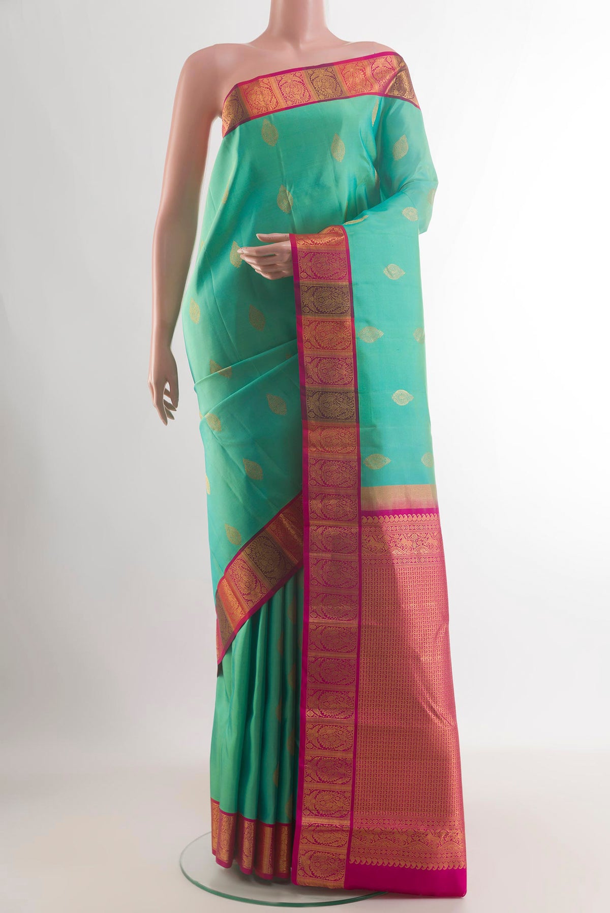 Pure Silk Green Kanchipuram Saree with Zari Butta on the body and Zari Border.  displayed on a mannequin